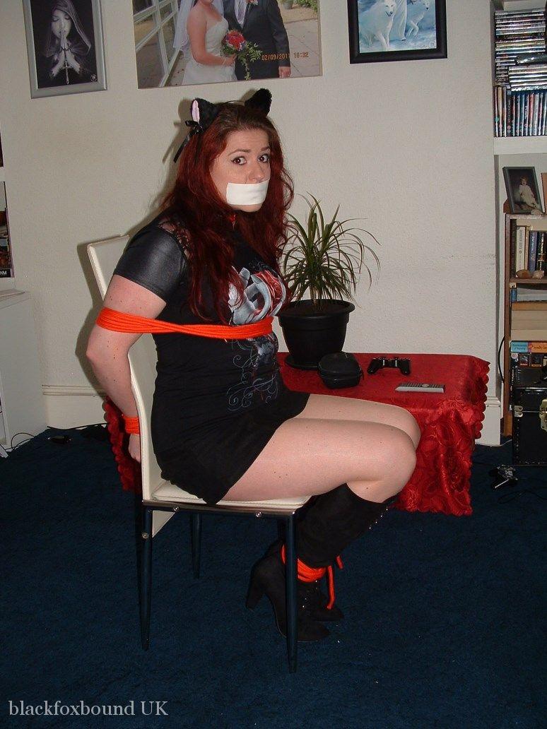 Thick redhead is tied to a chair with tape affixed to her mouth порно фото #429041173
