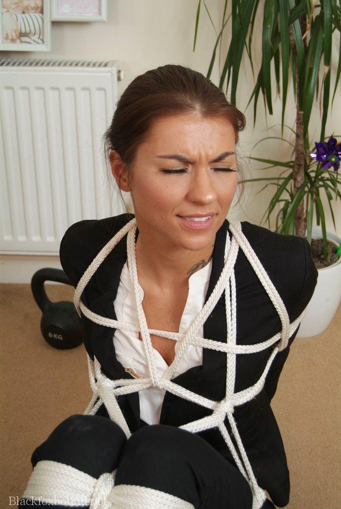 After being tied up with rope, a woman in her own clothing is held in place.