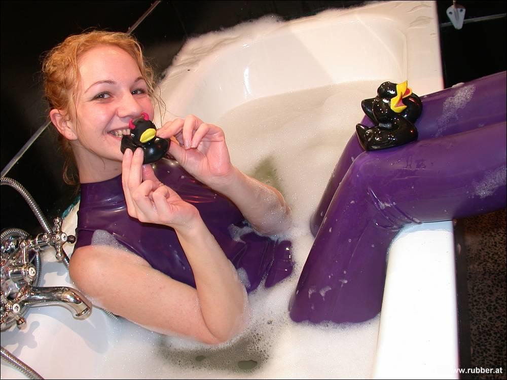 White girl wears purple latex and she shows her bare feet in the bath.