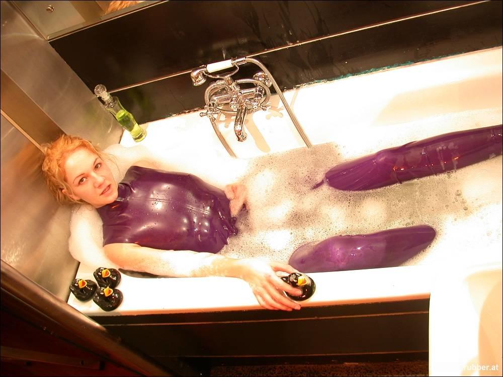 White girl wears purple latex and she shows her bare feet in the bath.