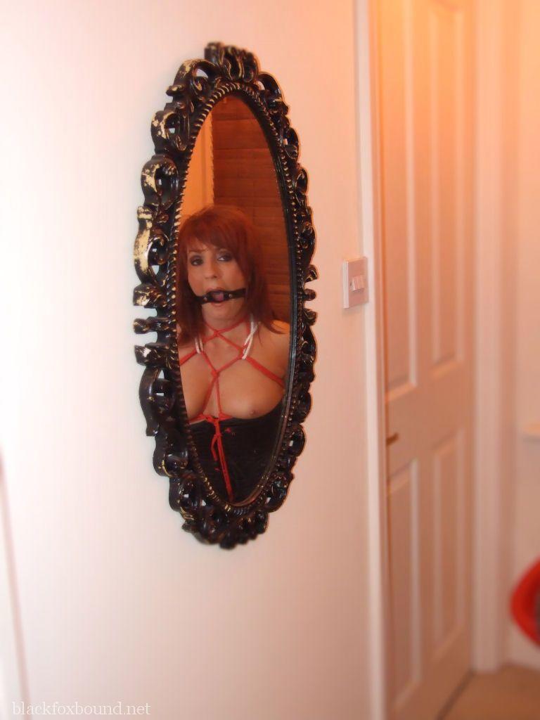 Multiple pairs of pantyhose are worn by the redhead female and ball gagged.