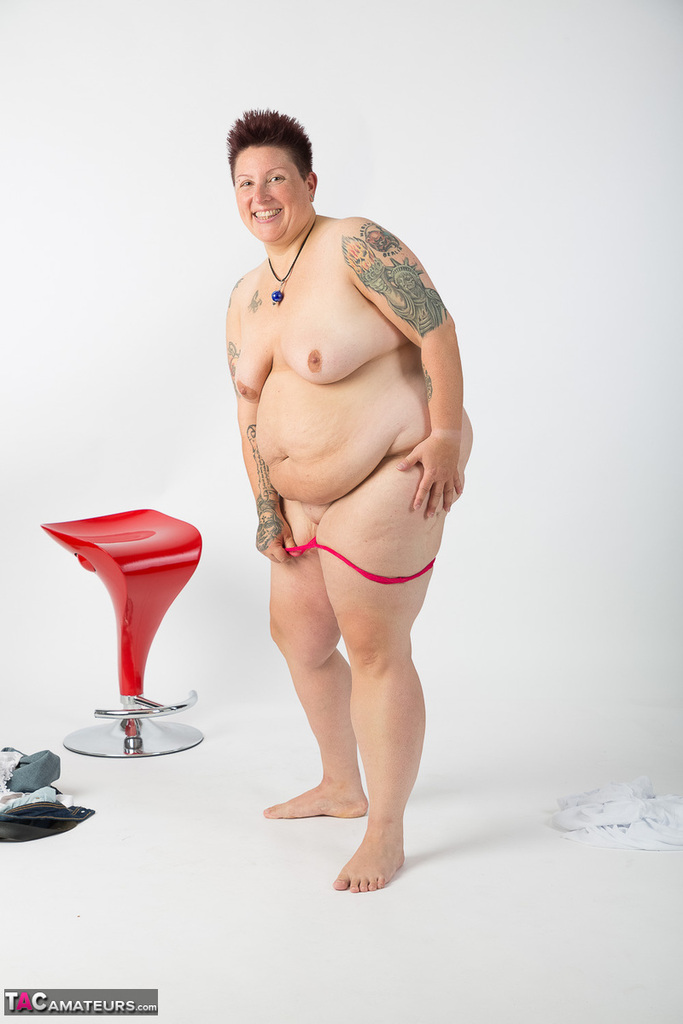 Obese amateur Tattoo Girl sits on a stool after getting totally naked