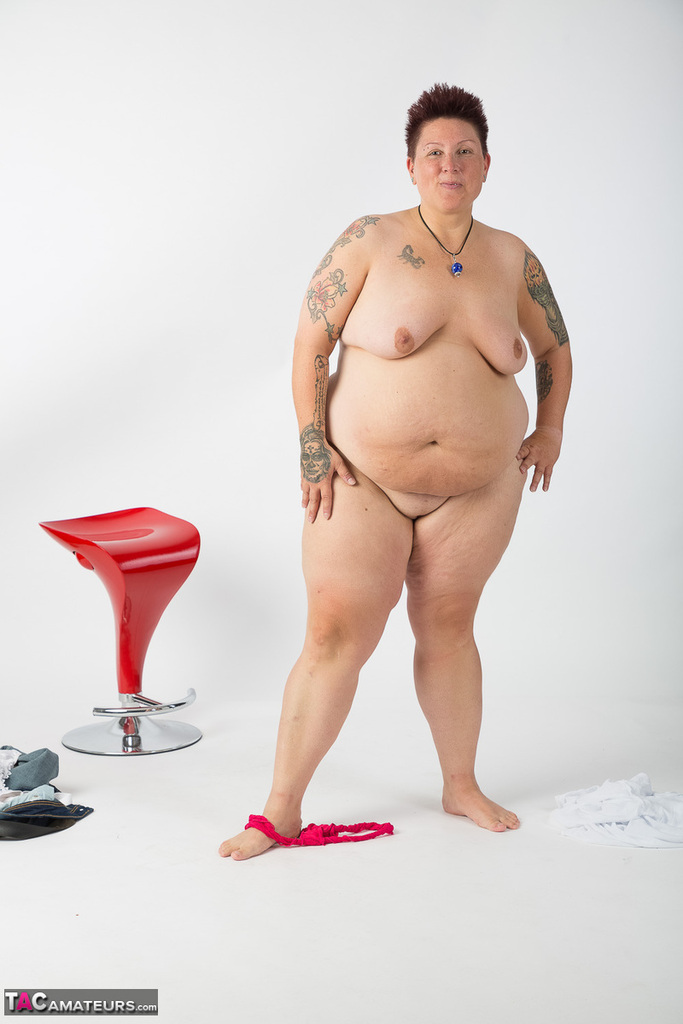 After being stripped down to her bare hands, an elderly Tattoo Girl who is not a professional takes it upon herself to sit on a stool.