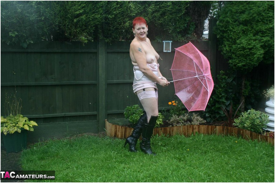Older redhead Valgasmic Exposed models nude in the rain while holding a brolly Porno-Foto #424895919