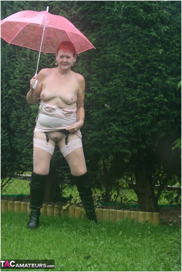Older redhead Valgasmic Exposed models nude in the rain while holding a brolly porn photo #424895932