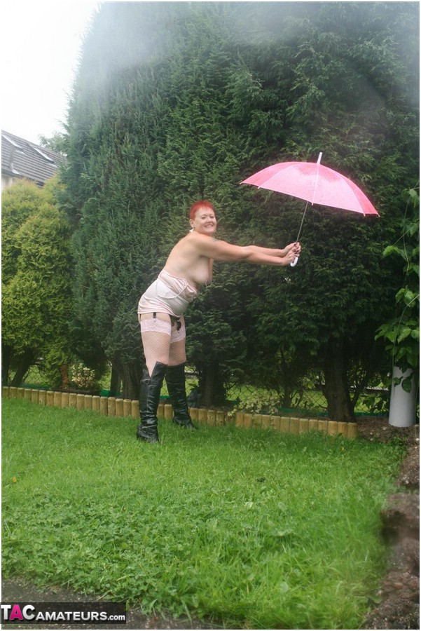 Older redhead Valgasmic Exposed models nude in the rain while holding a brolly porn photo #424895936