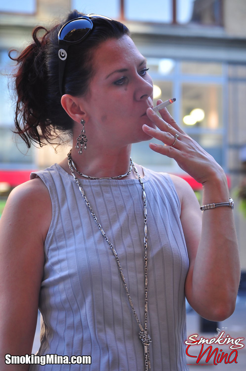 Brunette chick smokes a cigarette on a busy street while fully clothed foto porno #424141499