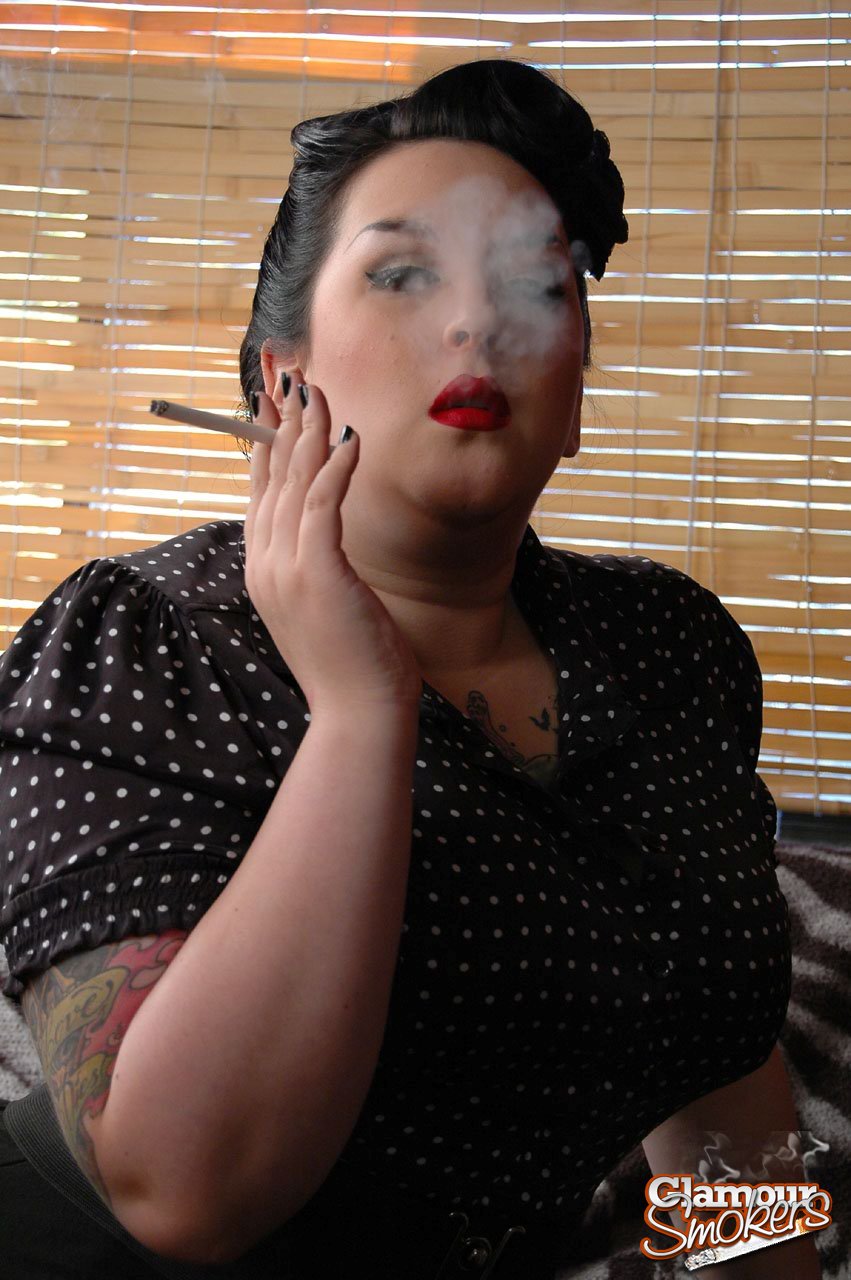 Kerosene instills a reddish-loud image of a fully clothed, overweight woman smoking cigarettes while she wraps her face around her red lips