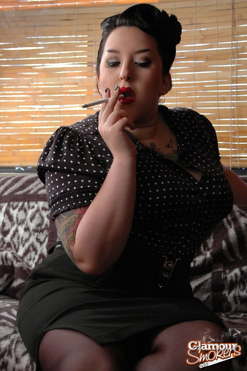 The woman who is fully clothed and fat, with Kerosene in her pocket around her red lips, smokes from a smoking cigar.