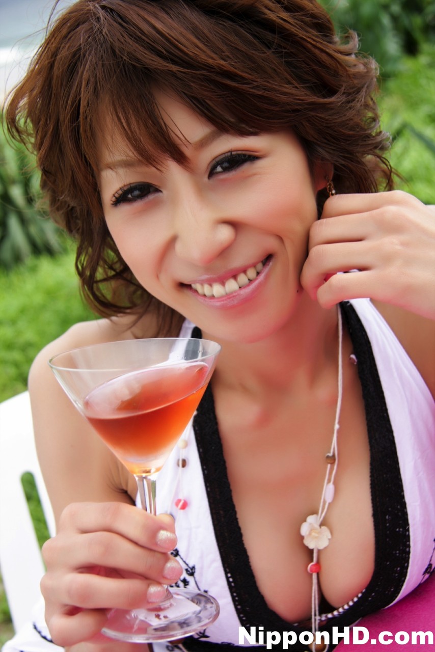 Pretty Japanese woman displays her cleavage over a cocktail near the ocean porn photo #427082660