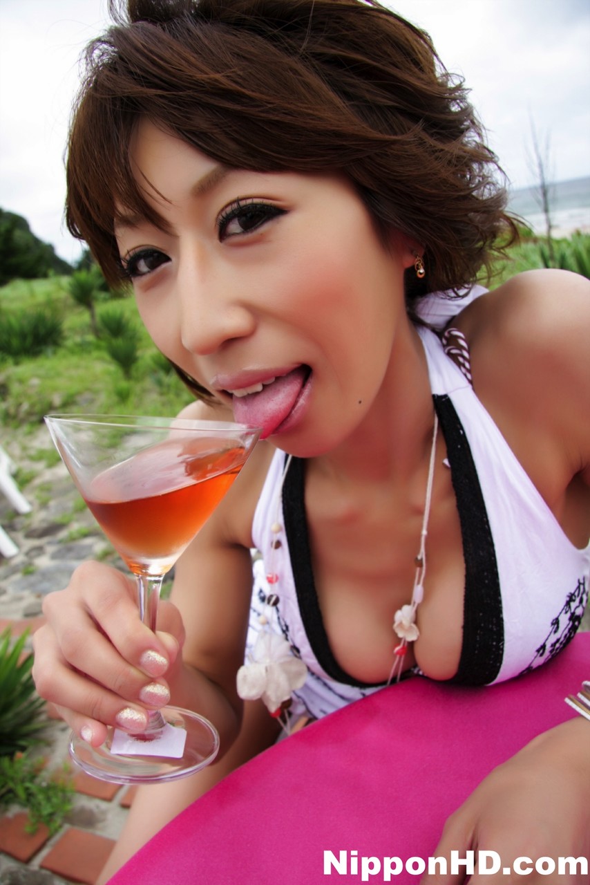 Pretty Japanese woman displays her cleavage over a cocktail near the ocean Porno-Foto #427082664