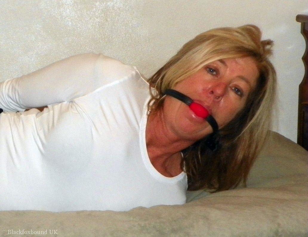 A black miniskirt bed, the naked blonde MILF is held over and ball gagged.