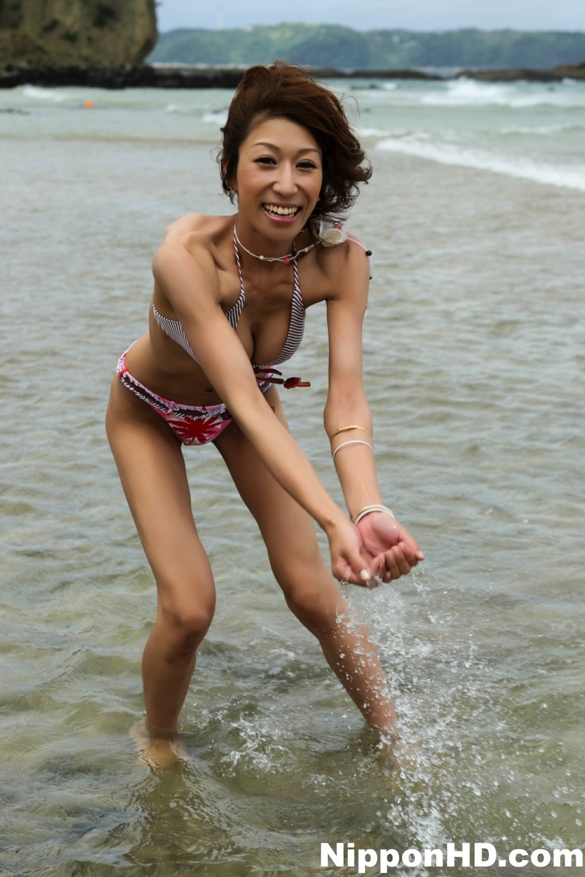 Japanese girl wears a bikini while playing in the ocean during a beach holiday foto porno #428452050 | Beach, porno móvil