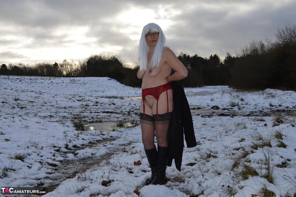 Mature platinum blonde gets naked on snow-covered ground in black boots porn photo #422941206