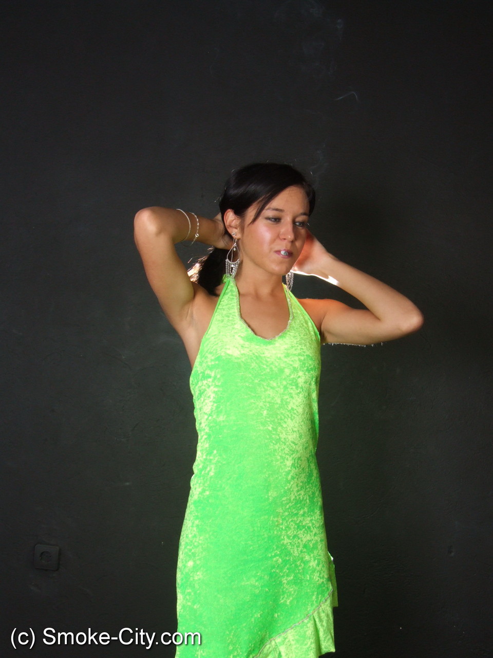 Dark haired teen wears a lime dress and pointy heels while smoking photo porno #426507735