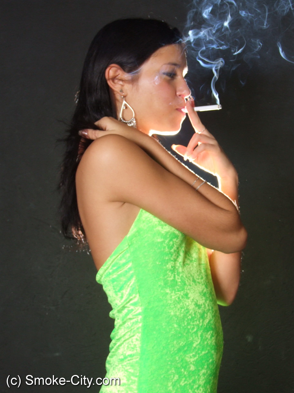 Dark haired teen wears a lime dress and pointy heels while smoking porn photo #426507739