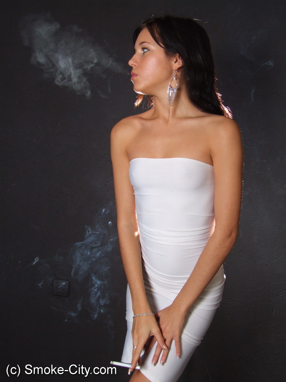 Young brunette smokes a cigarette while wrapped in tight white dress and heels porn photo #426521983