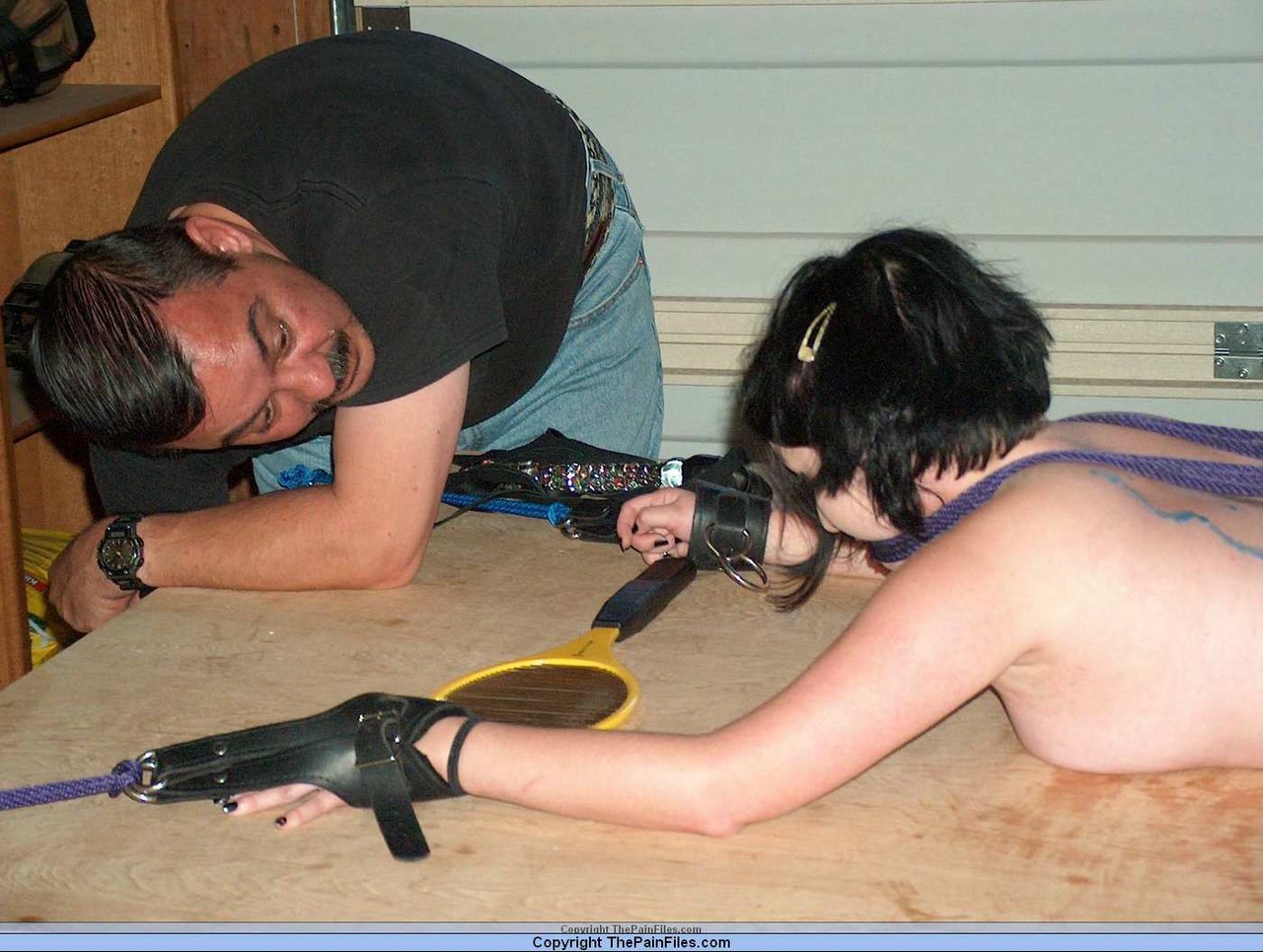 While in bondage, a girl with dark hair is subjected to hot wax that covers her posterior.