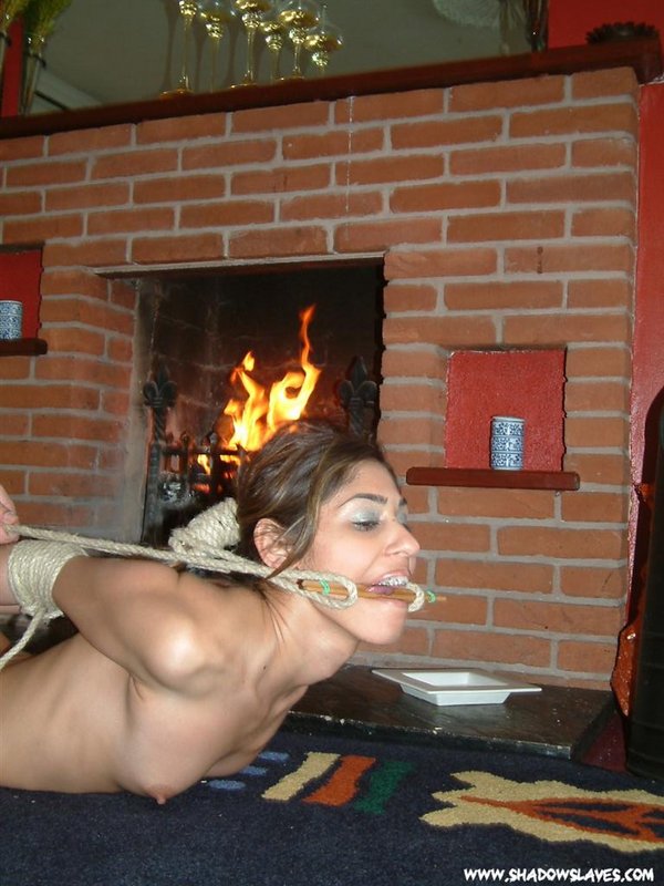 Naked Latina girl is gagged and rope bound in front of a fireplace foto porno #427216392