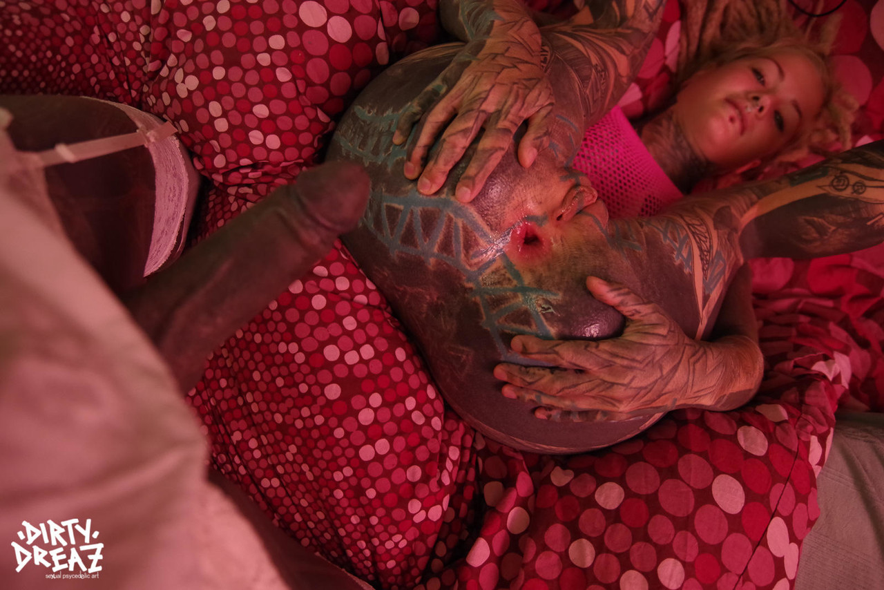 An asshole with extensive tattooed hands is stretched out by a heavily tattooed woman using her fingers to close it.