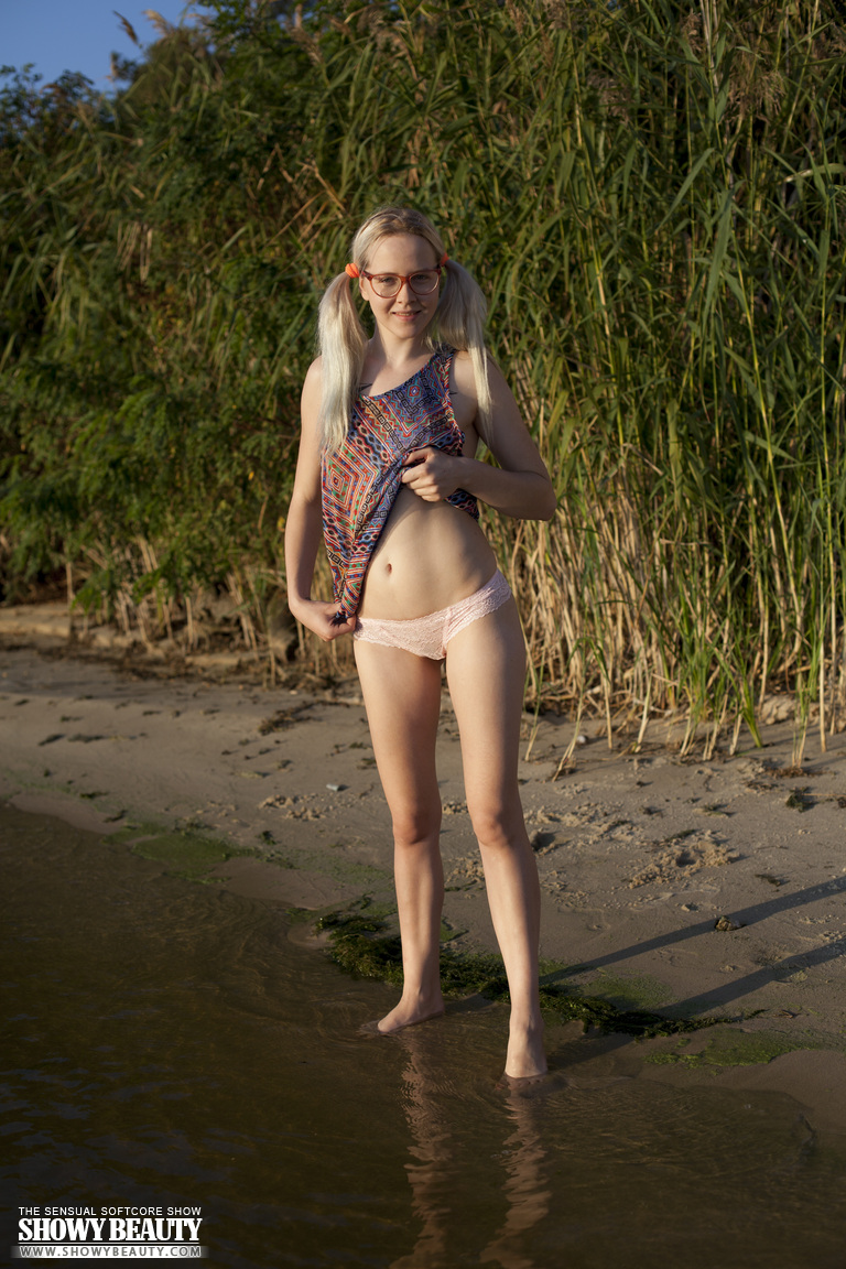 After wading into a lake without clothes on, Nerdy amateur Nika splashes water.