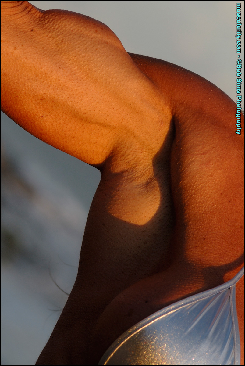 Bodybuilder Lynnie Brooks Poses On A Sandy Beach While Wearing A Silver Bikini