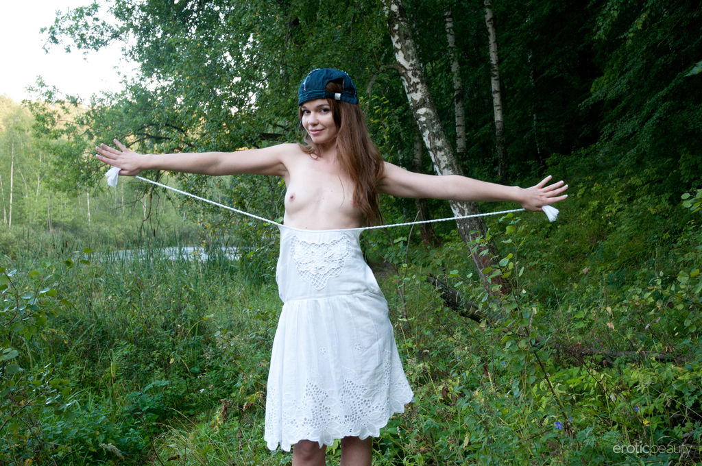 Cute teen Nedda A takes off a white dress to pose nude on a fallen tree Porno-Foto #427761473