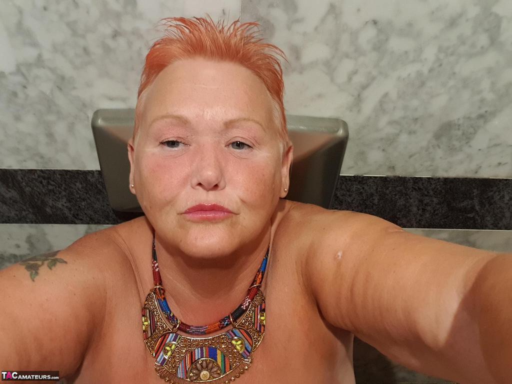 Selfies at home: The overweight woman with red hair goes for nude photos while on vacation.