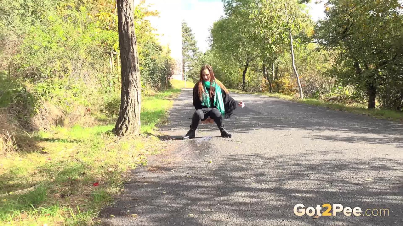 Caucasian girl Cynthia Vellons takes a piss while walking along a paved road порно фото #428538318