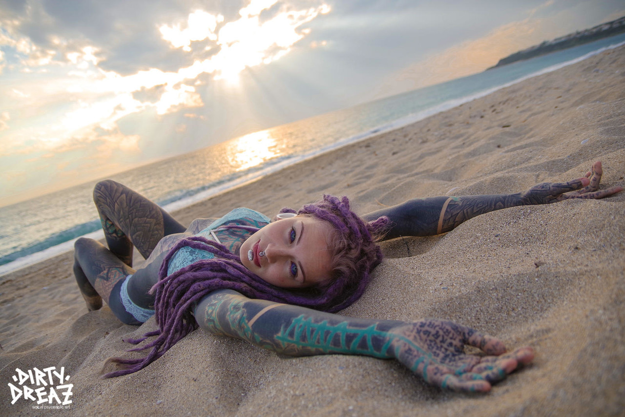 Heavily tattooed girl releases tiny tits from bikini top on a sandy beach foto porno #426703760