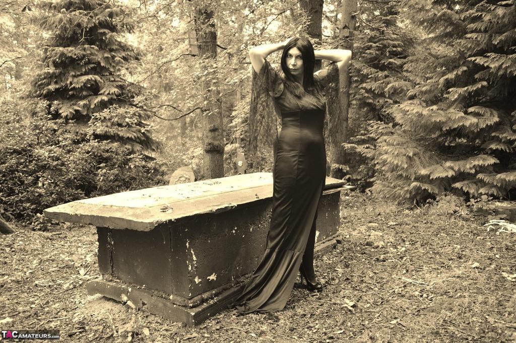 Goth girl Barby Slut bares her big tits and twat atop a casket in the woods porn photo #422845287