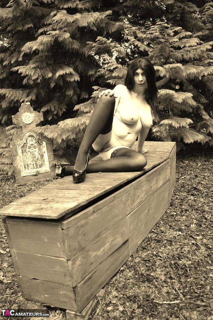 Goth girl Barby Slut bares her big tits and twat atop a casket in the woods foto porno #423239807