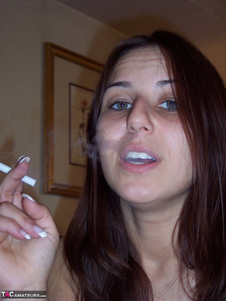 Totally naked girl Lexxxi sits on her bed while smoking a cigarette porno foto #424135032