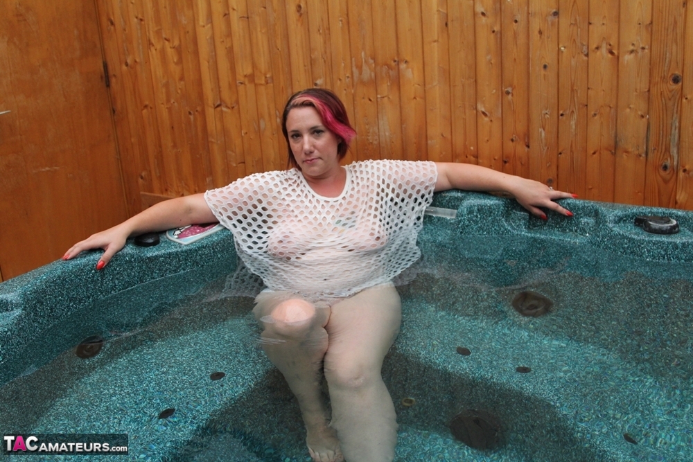 Plump amateur removes a mesh top while relaxing in an outdoor hot tub porn photo #424819034