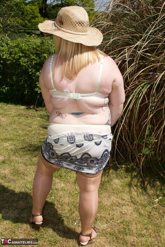 Blonde BBW makes her nude debut in a yard while wearing a hat and tan hosiery porn photo #425487478