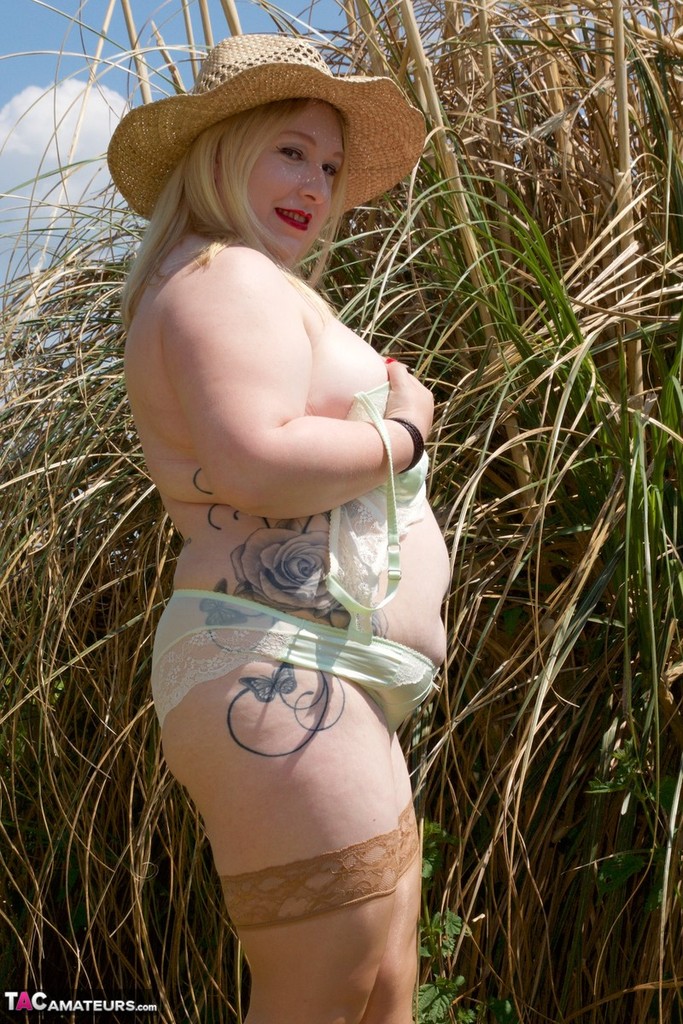 Blonde BBW makes her nude debut in a yard while wearing a hat and tan hosiery porn photo #425487482