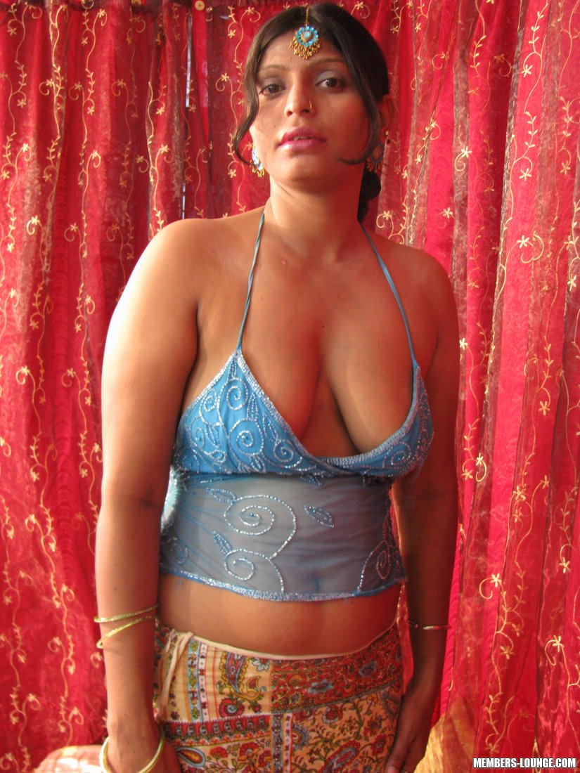 Chubby, curvy Indian woman exposes her natural tits and freshly mopped pussy on a bed.