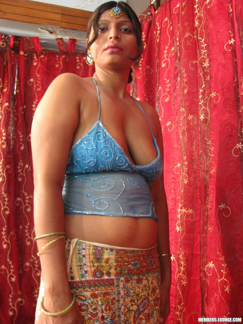 On a bed, a sluggish Indian woman displays her natural tits and shaved off body.