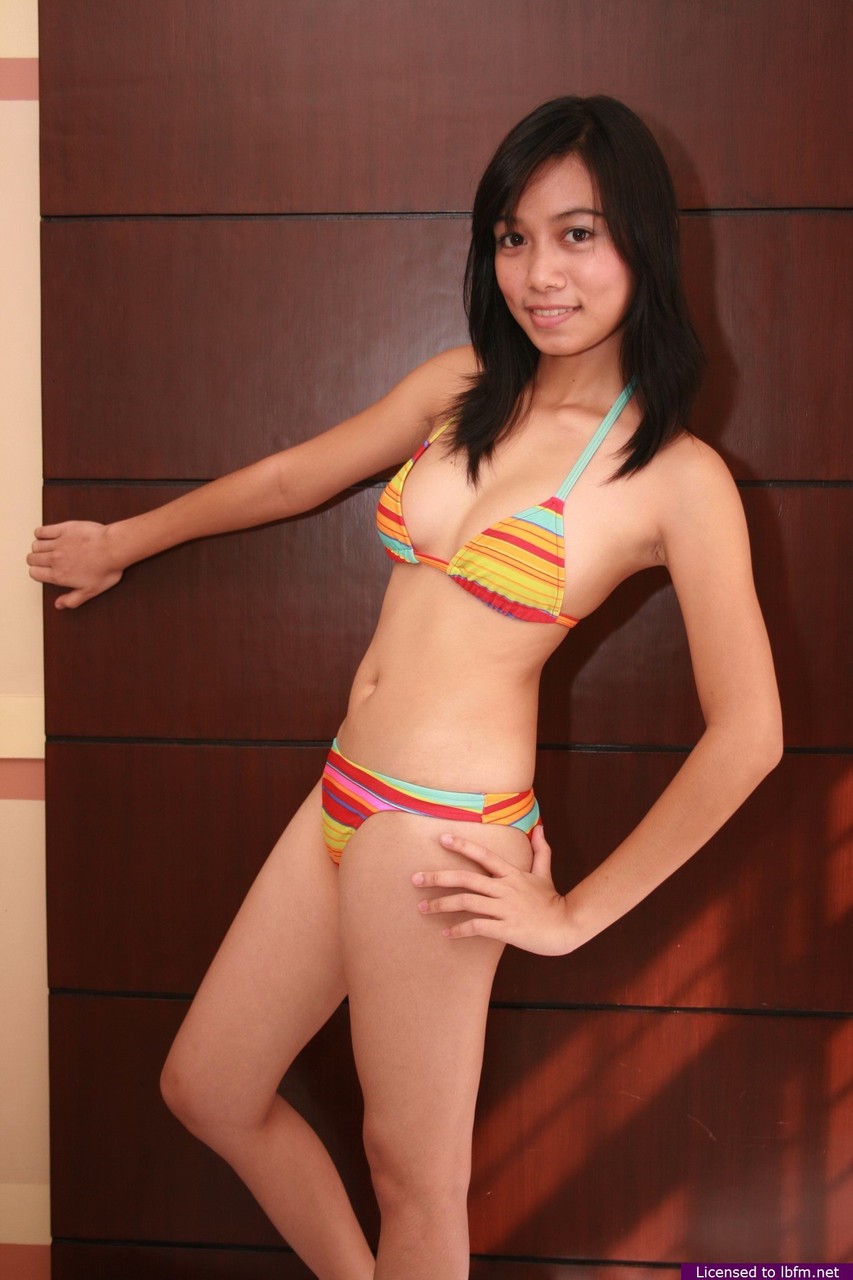 Asian teen Janelyn works free of her bikini to pose nude upon a bed Porno-Foto #425616399