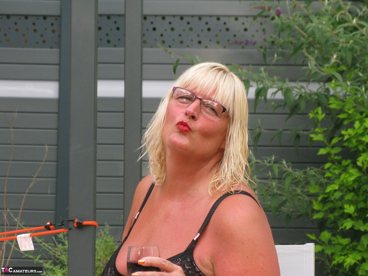 Older blonde BBW Chrissy Uk gives a BJ after going topless in a garden setting porn photo #428341424