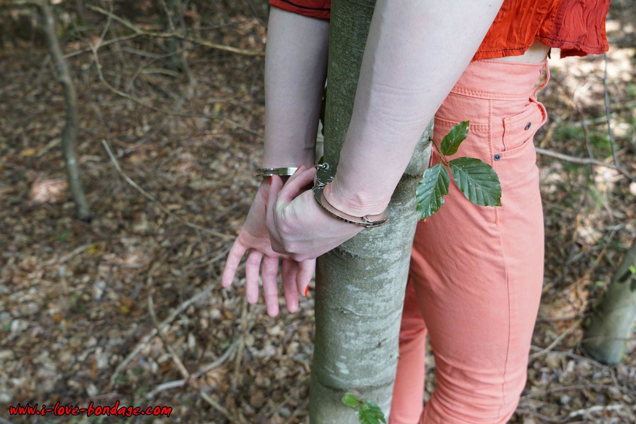 Clothed girl in canvas sneakers finds herself handcuffed to a tree in woods porno foto #427194856
