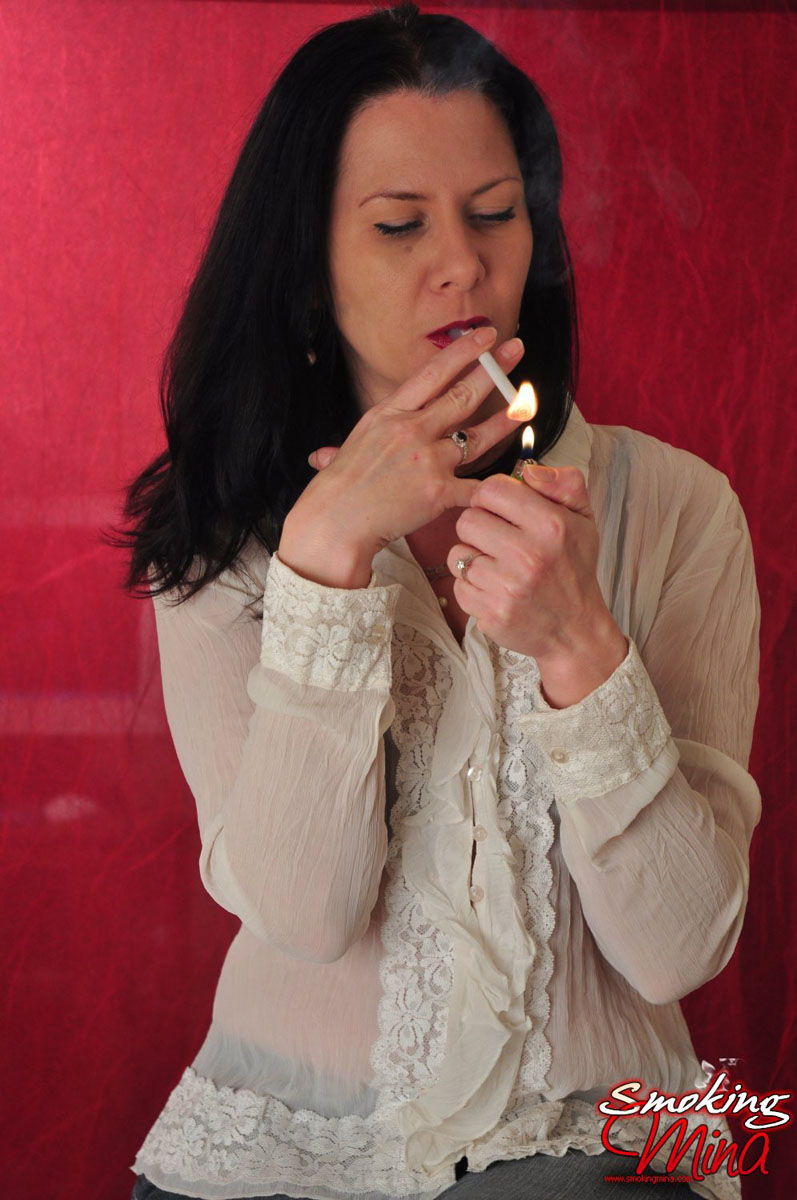 Brunette chick wears a sheer blouse while enjoying a smoke porn photo #428683867