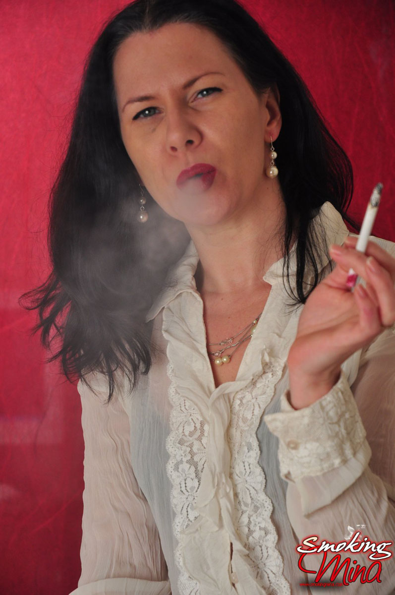 Brunette chick wears a sheer blouse while enjoying a smoke porn photo #428683885
