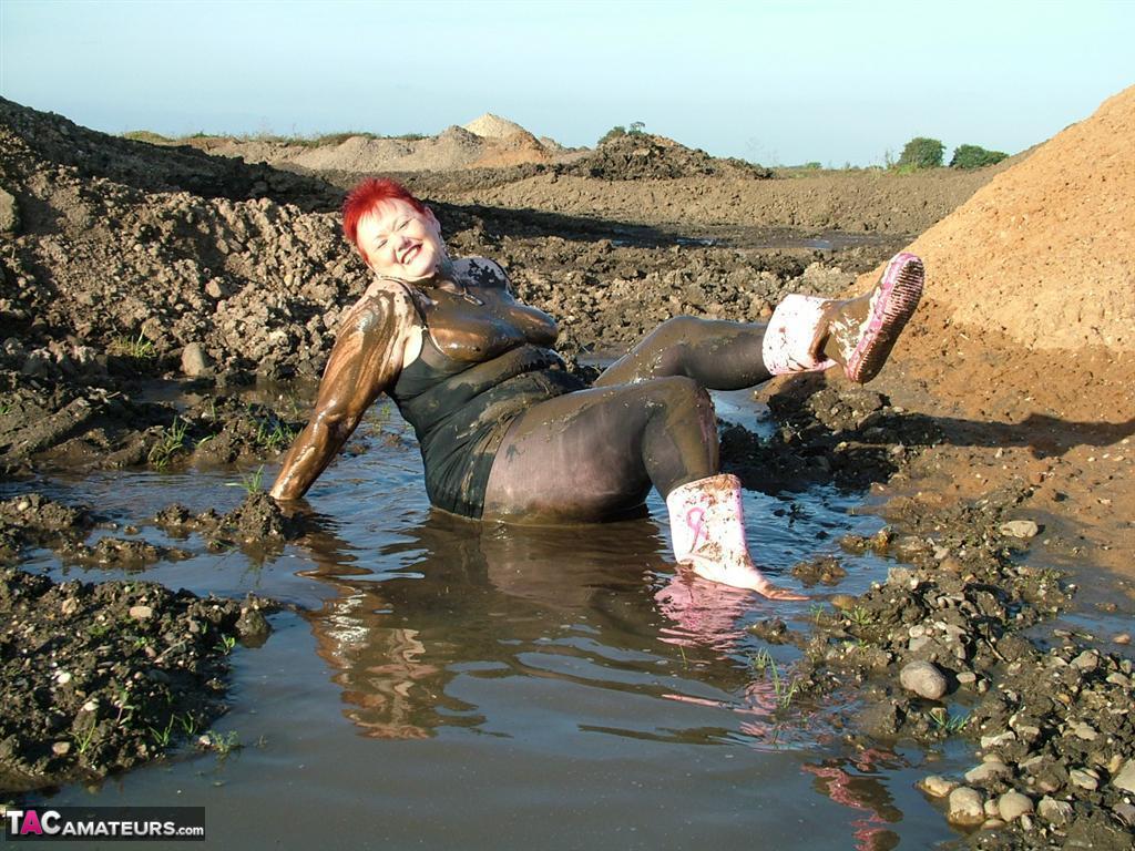 Mature redhead Valgasmic Exposed covers her fat body in mud porn photo #424734960