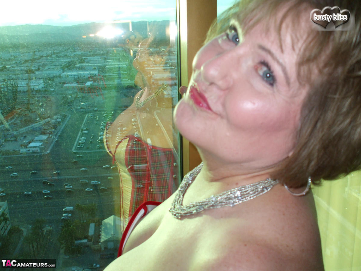 Mature woman Busty Bliss looses her big tits from a corset by her condo window photo porno #428649290