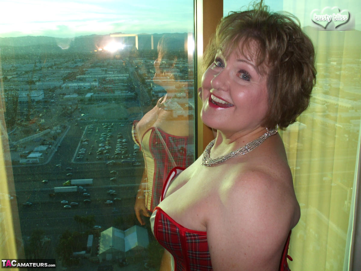 Mature woman Busty Bliss looses her big tits from a corset by her condo window photo porno #428649292