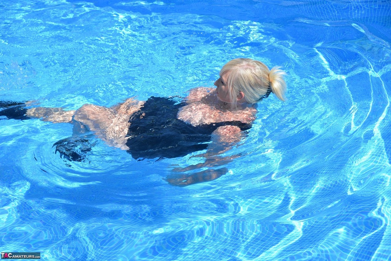Thick blonde Melody displays her ample cleavage while fully clothed in a pool porn photo #426789620