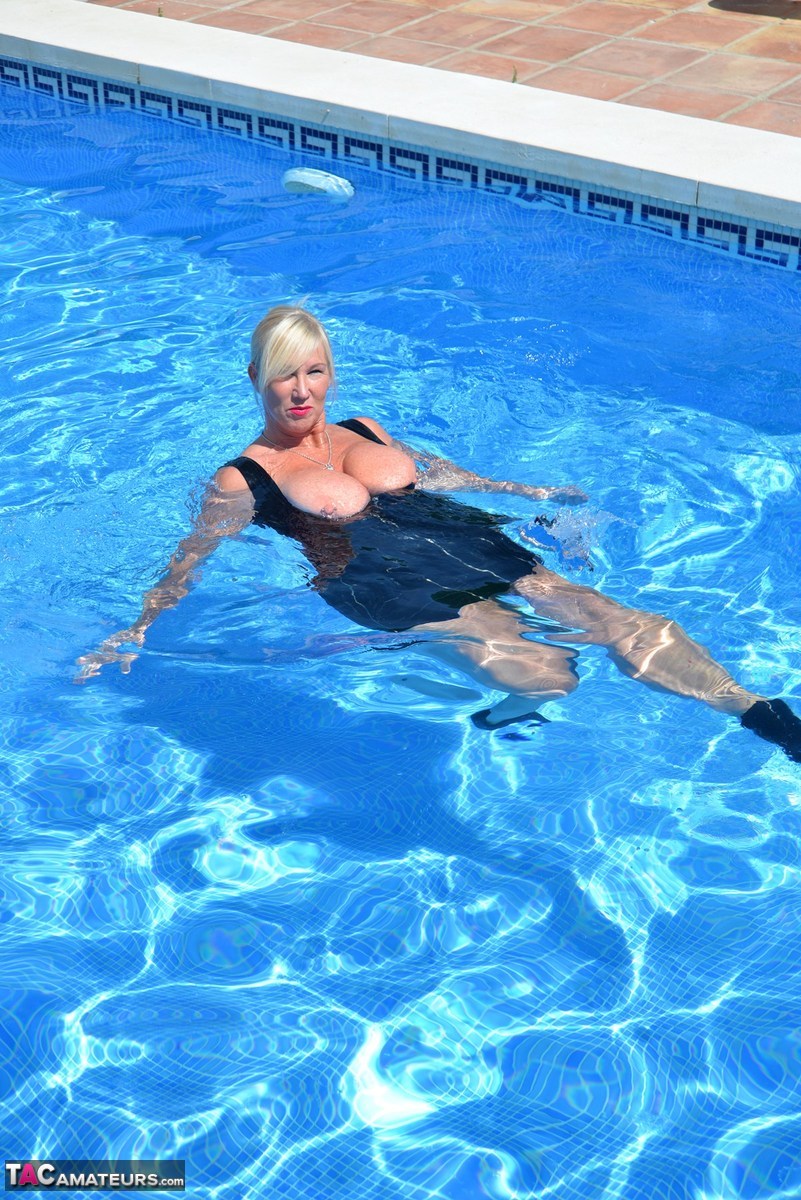 Thick blonde Melody displays her ample cleavage while fully clothed in a pool porn photo #426789627