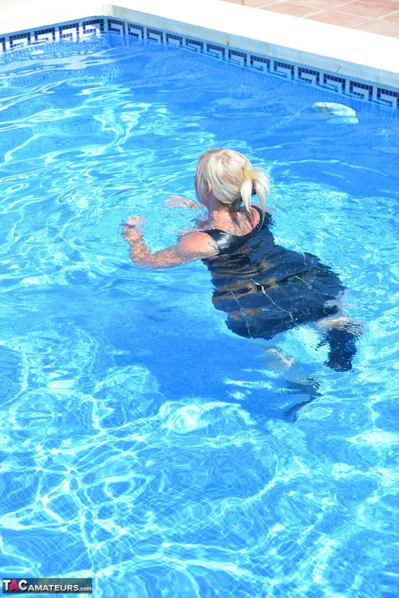 Thick blonde Melody displays her ample cleavage while fully clothed in a pool porn photo #426789629