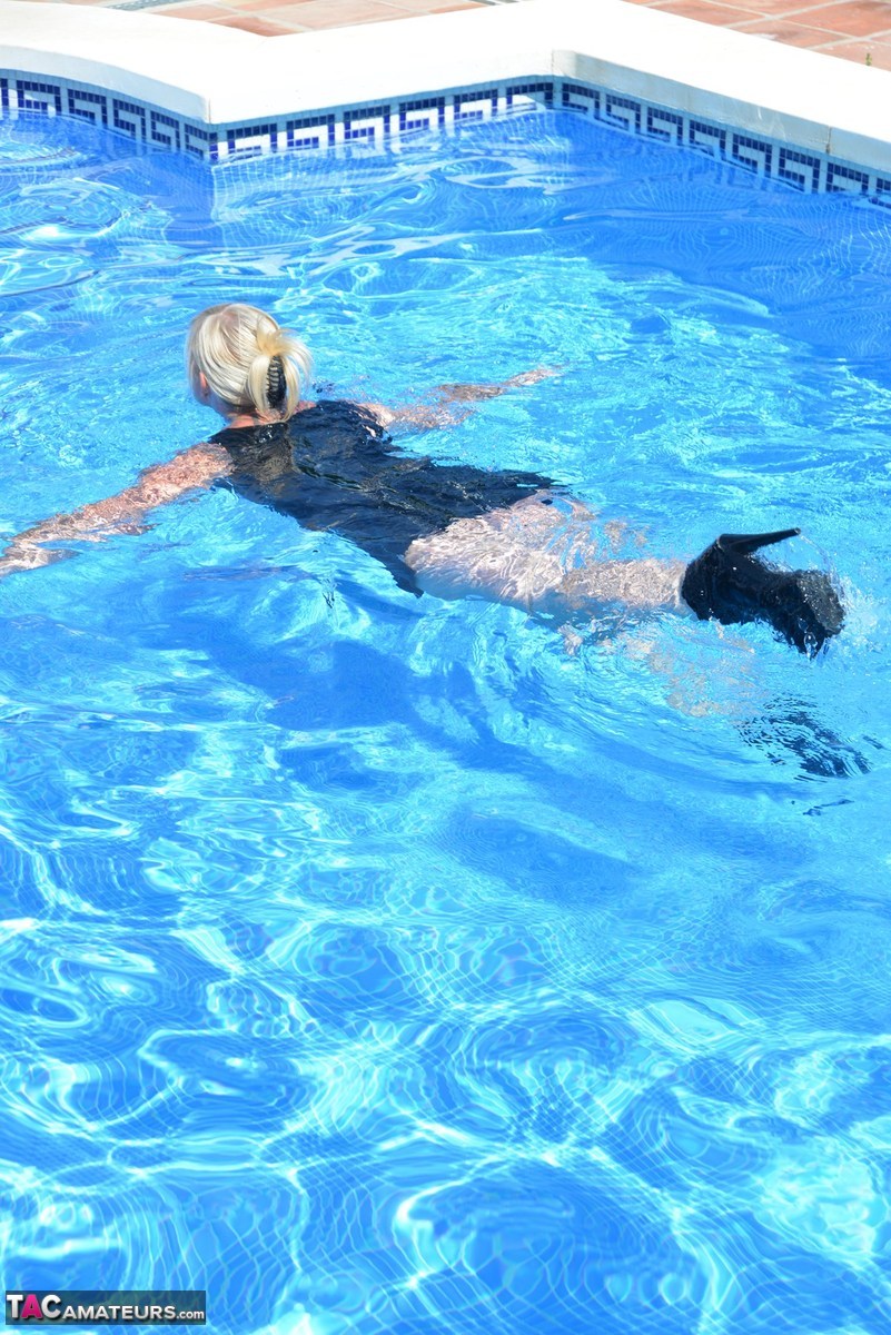Thick blonde Melody displays her ample cleavage while fully clothed in a pool photo porno #426789632
